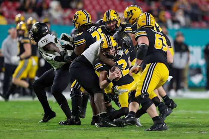 Dec 23, 2022; Tampa, Florida, USA; Missouri Tigers quarterback Brady Cook (12) is sacked by Wake Forest Demon Deacons defensive lineman Kobie Turner (0) in the fourth quarter in the 2022 Gasparilla Bowl at Raymond James Stadium. Mandatory Credit: Nathan Ray Seebeck-USA TODAY Sports